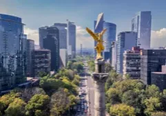 The golden Angel of Independence monument stands tall in Mexico City, surrounded by modern skyscrapers and lush trees. This iconic landmark symbolizes Mexico’s history and resilience.