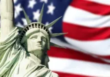 the statue of liberty with blurred american flag waving in the background. Democracy and freedom concept.